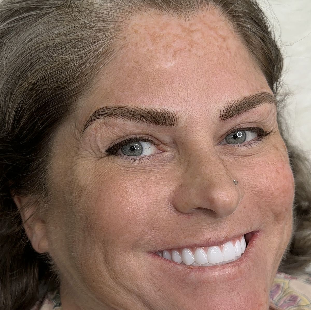 Smiling client showing full, polished brows