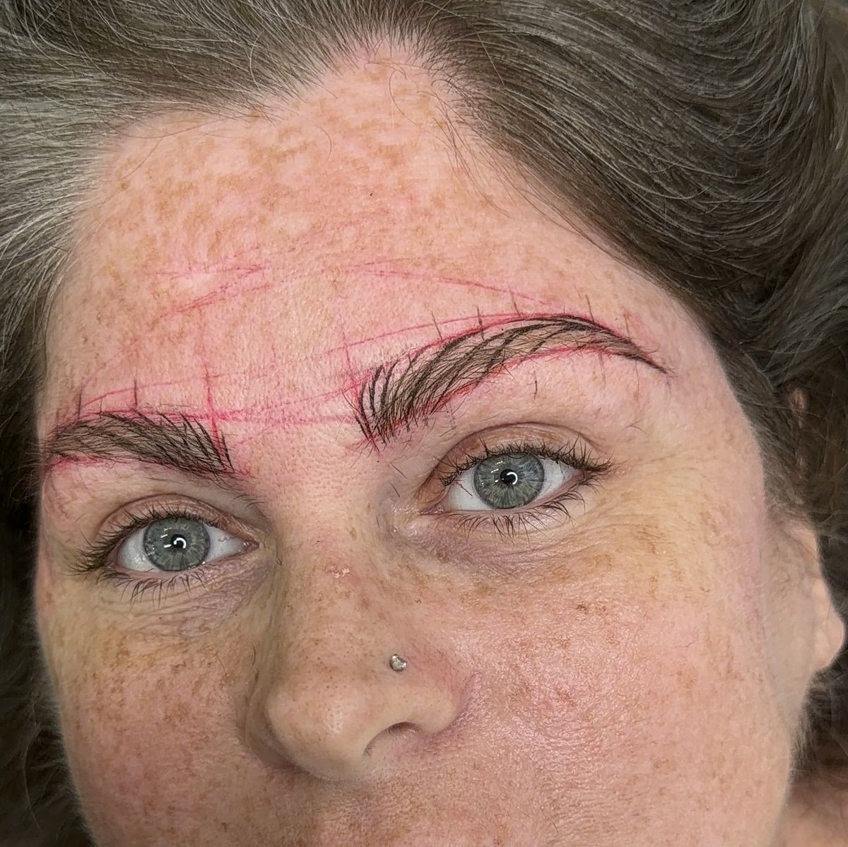 Brow mapping drawn on a client before the procedure